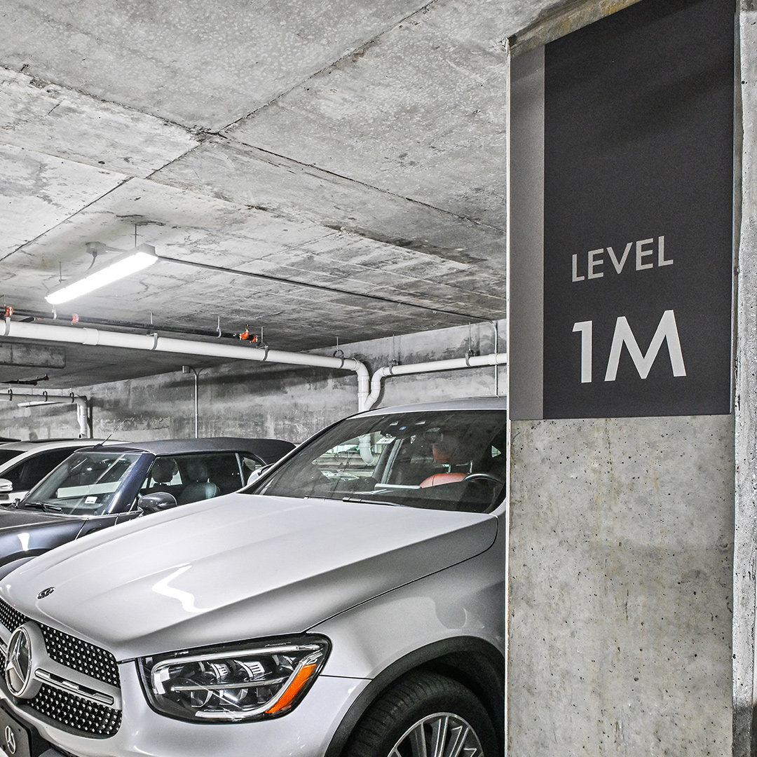 A clean minimalist level indicator sign mounted to a column in a parking garage ramp